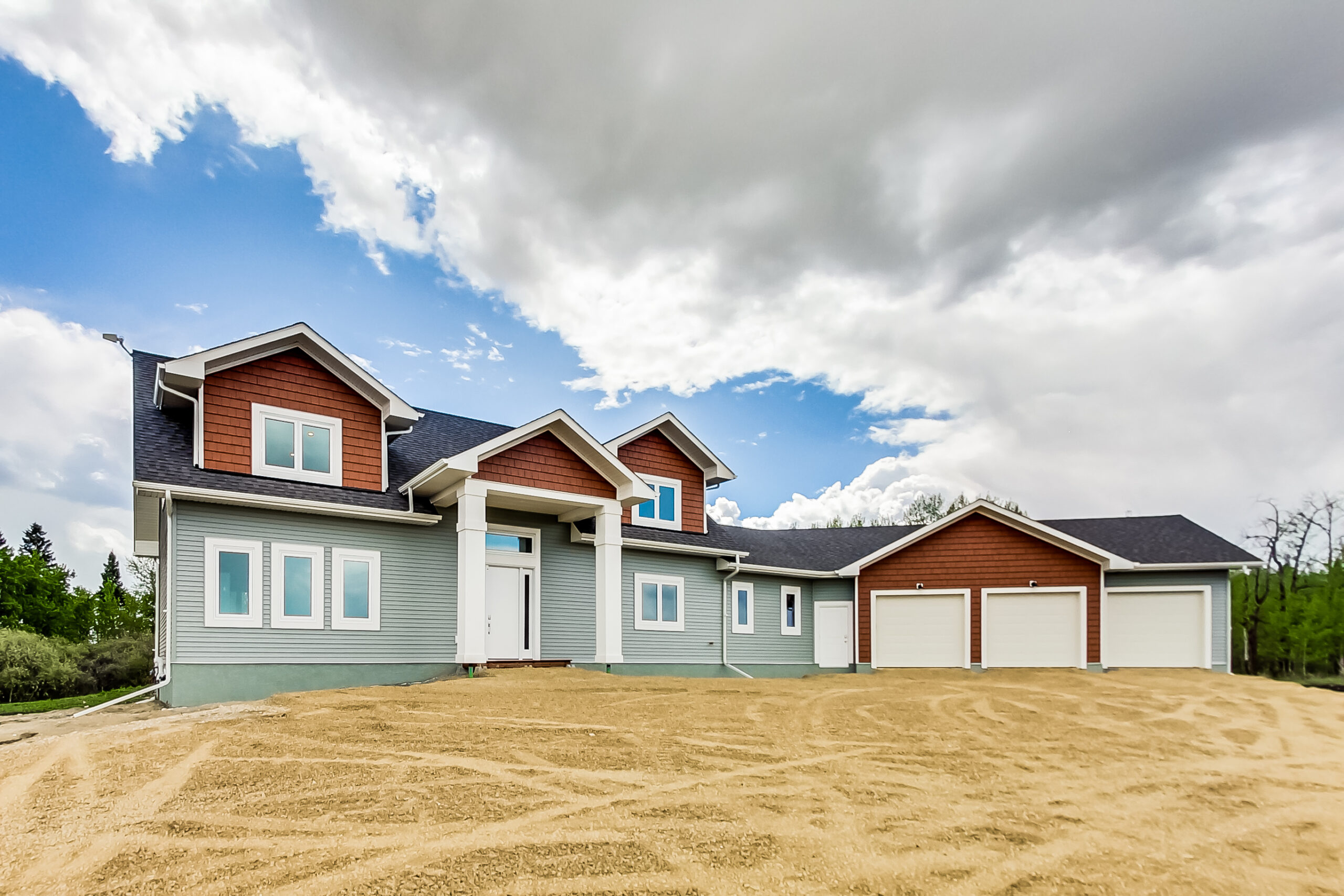 exterior of a home with a triple car garage and large pillars in front of main exterior door