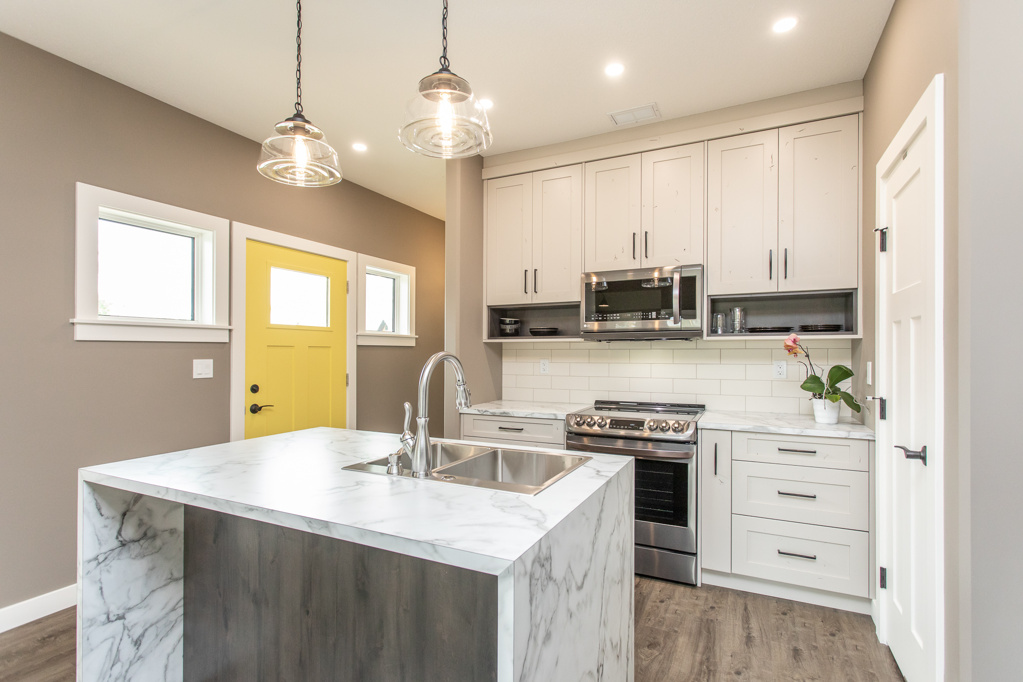 kitchen with waterfall island. yellow exterior door in background