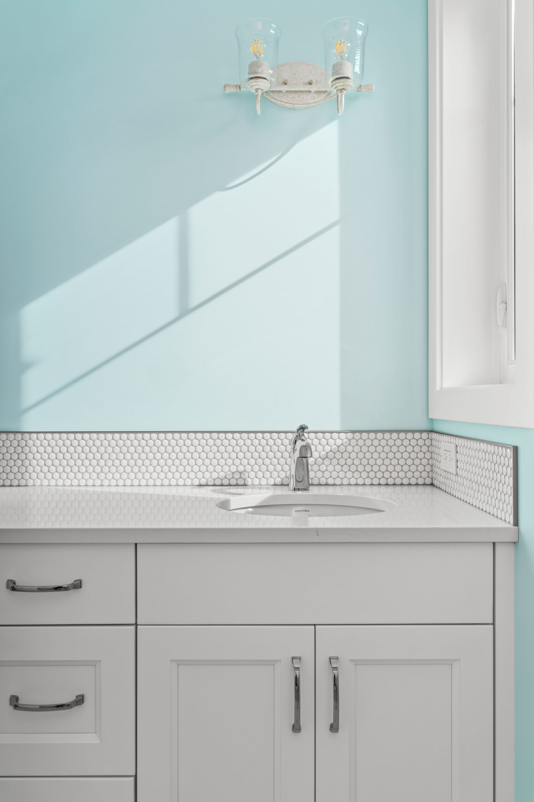 close up picture of bathroom sink. light blue painted wall