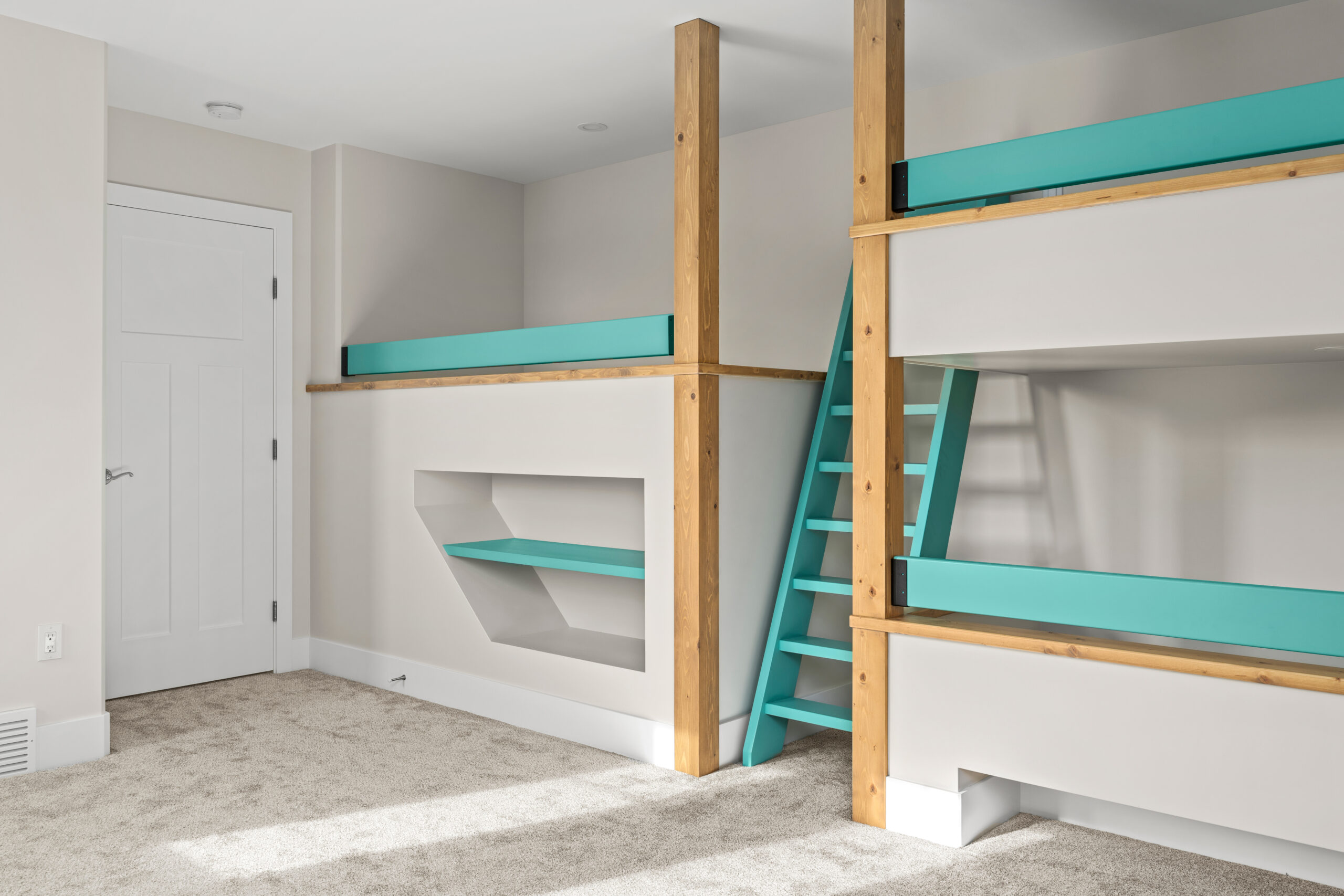 3 custom built bunk beds with a blue ladder between. There is a bookshelf under one bunk.