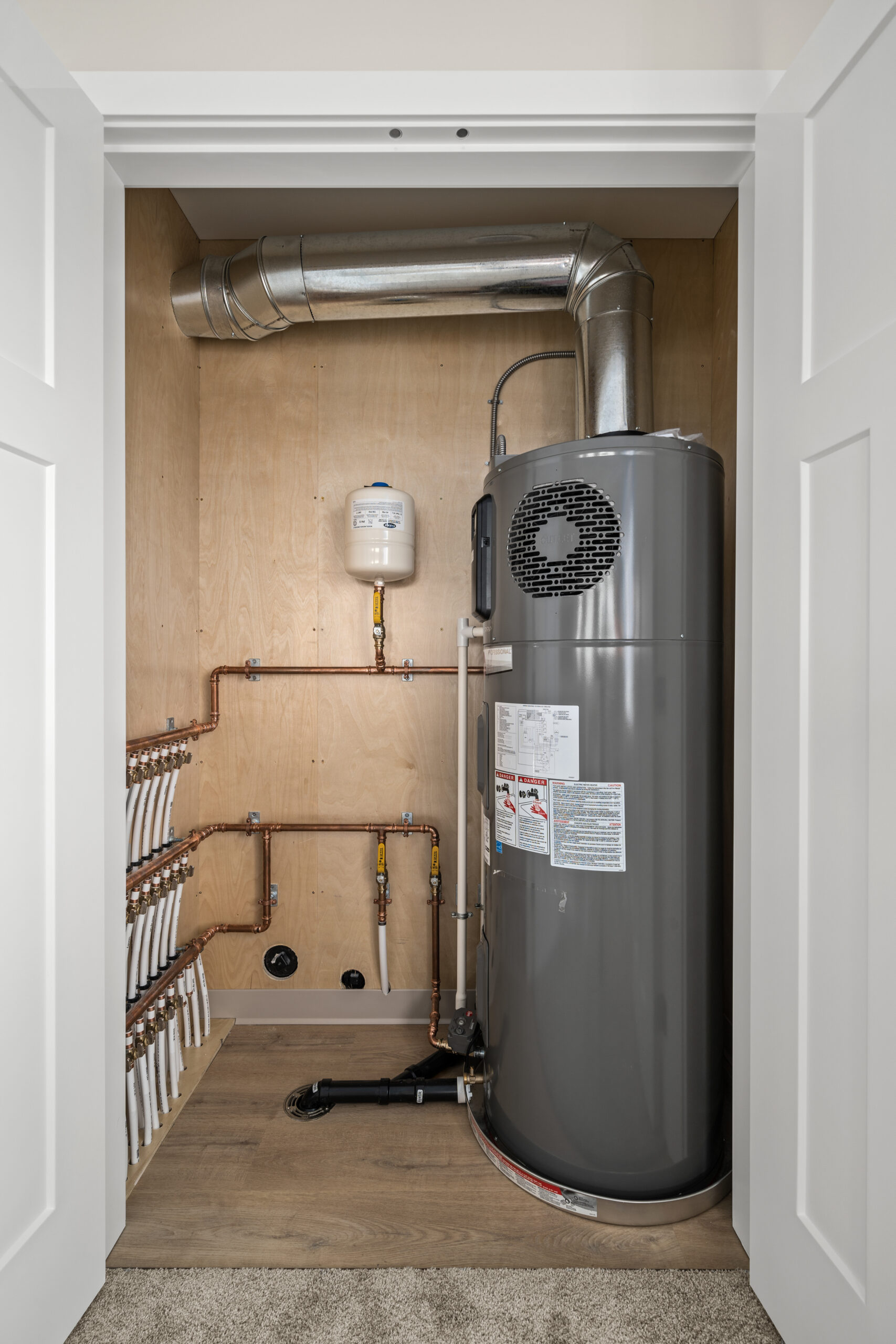 mechanical room showing home run water lines and heat pump hot water tank
