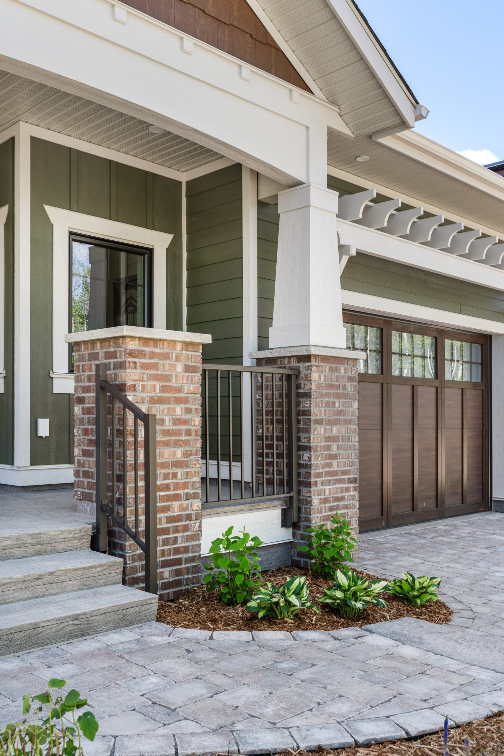 custom craftsman bungalow home built by Vleeming Custom Homes with brick pillars at front deck