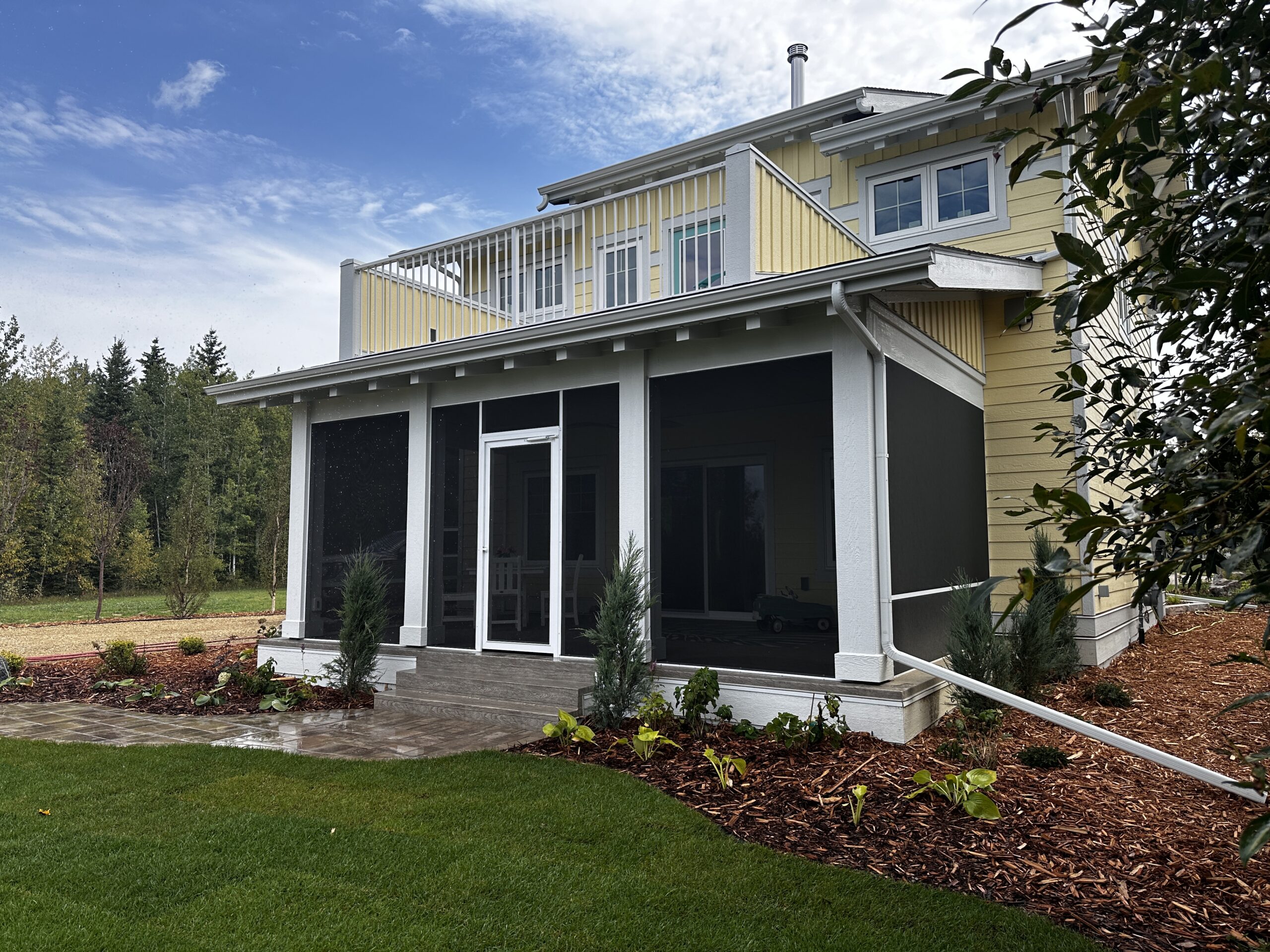 covered deck on a yellow home