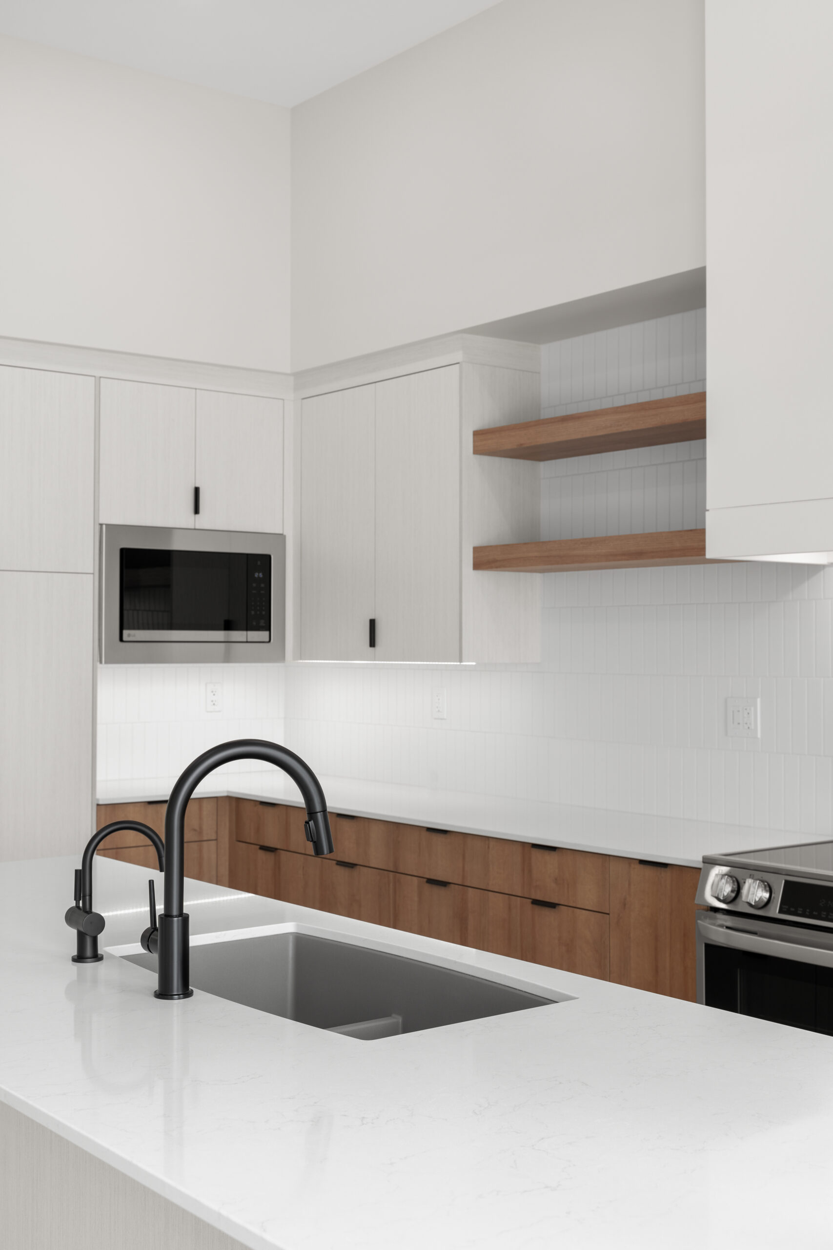 kitchen cabinetry, microwave and sink in a net zero home